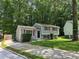 Charming two-story home with gray siding, red shutters, and a well-maintained lawn in a lush, green neighborhood at 2036 Countydown Ln, Stone Mountain, GA 30088
