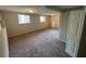 Spacious carpeted living room has natural light with windows, a door, and neutral paint at 2036 Countydown Ln, Stone Mountain, GA 30088