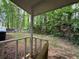 Covered back porch featuring wooden railings and a view of the private, tree-lined yard at 2036 Countydown Ln, Stone Mountain, GA 30088