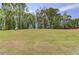 A large grassy backyard with mature trees and a partly cloudy sky at 37 Deer Canyon Dr, Auburn, GA 30011
