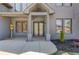 Stately gray brick home featuring a covered front entrance with stone columns and meticulous landscaping at 37 Deer Canyon Dr, Auburn, GA 30011