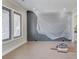 Unfinished living room with large windows and a covered accent wall, ready for personalization at 37 Deer Canyon Dr, Auburn, GA 30011