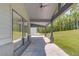 Covered porch with concrete flooring, gray columns and treed backyard at 37 Deer Canyon Dr, Auburn, GA 30011