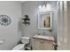 Powder room includes granite vanity, decorative shelves and a neutral color scheme at 5574 Wynhall Dr, Peachtree Corners, GA 30071