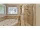 Bright bathroom with soaking tub, glass shower, and tiled walls at 5574 Wynhall Dr, Peachtree Corners, GA 30071