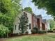 Side exterior view showing the brick and siding materials, windows, and landscaping at 5574 Wynhall Dr, Peachtree Corners, GA 30071