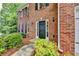 Close-up of a home's brick facade and front door, showing the landscaped entryway at 5574 Wynhall Dr, Peachtree Corners, GA 30071