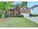 Charming two-story brick home featuring a well-manicured lawn and inviting curb appeal at 5574 Wynhall Dr, Peachtree Corners, GA 30071