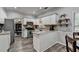 Well-lit kitchen features white cabinets, stainless steel appliances, and speckled granite countertops at 5574 Wynhall Dr, Peachtree Corners, GA 30071