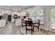 Lovely kitchen features white cabinetry, wood floors, granite countertops and an eat-in area with a wood table at 5574 Wynhall Dr, Peachtree Corners, GA 30071