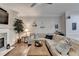 Spacious living room with a comfortable sectional couch, decorative fireplace, shelving, ceiling fan and wood flooring at 5574 Wynhall Dr, Peachtree Corners, GA 30071