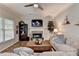 Cozy living room features a decorative fireplace, built-in shelving, ceiling fan and large windows for plenty of natural light at 5574 Wynhall Dr, Peachtree Corners, GA 30071