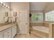 Well-lit main bathroom with double sinks, glass vessel bowls, and a separate soaking tub at 5574 Wynhall Dr, Peachtree Corners, GA 30071