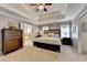 Large main bedroom with tray ceilings, ceiling fan, neutral decor and an ensuite bathroom at 5574 Wynhall Dr, Peachtree Corners, GA 30071