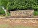 Community stone sign for Wyntree, adorned with greenery and subtle lighting, creates a welcoming neighborhood entrance at 5574 Wynhall Dr, Peachtree Corners, GA 30071
