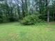 Lush green backyard with trees and greenery, creating a serene, private outdoor space at 5769 Shadow Creek Dr, Lithonia, GA 30058