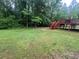 Expansive backyard with mature trees, and a wooden deck with stairs at 5769 Shadow Creek Dr, Lithonia, GA 30058