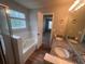 Bright bathroom features a double sink with granite countertop and a large soaking tub by a window at 5769 Shadow Creek Dr, Lithonia, GA 30058