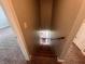 Carpeted staircase featuring wooden handrail leads to the lower level of the home, next to doorway at 5769 Shadow Creek Dr, Lithonia, GA 30058