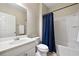 Bathroom features a white vanity, toilet and a shower and tub combo with dark blue shower curtain at 1355 Hesse Ln, Austell, GA 30106