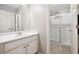 Bathroom with white vanity and framed mirror, a large glass shower, and tile flooring throughout at 1355 Hesse Ln, Austell, GA 30106