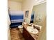 Cozy bathroom featuring a shower with a blue-striped curtain, wood-look floors and a vanity at 24 Samuel Nw Way, Cartersville, GA 30121