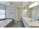 Spacious bathroom featuring a large vanity with double sinks, tub and tiled floors at 3390 Mill Valley Dr, Dacula, GA 30019