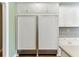 White kitchen boasts an integrated full-size fridge and freezer and ample storage at 3390 Mill Valley Dr, Dacula, GA 30019