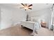 Bright primary bedroom with a ceiling fan and a wooden bed frame, complemented by neutral carpet at 461 Timberleaf Rd, Canton, GA 30115