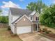 Charming two-story home with brick and white siding, a well-manicured lawn, and an attached two-car garage at 461 Timberleaf Rd, Canton, GA 30115
