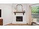 Close-up of a fireplace with a brick surround, a wooden mantel and large mirror at 461 Timberleaf Rd, Canton, GA 30115