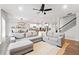 Spacious living room featuring a large sectional sofa, ceiling fan, and open layout to the kitchen and dining area at 461 Timberleaf Rd, Canton, GA 30115