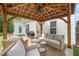 Inviting covered patio area with comfortable seating and a grill, perfect for outdoor entertaining at 461 Timberleaf Rd, Canton, GA 30115