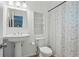 Bathroom features a white pedestal sink and white and black speckled shower curtain at 495 Ramsdale Dr, Roswell, GA 30075