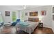 Bright bedroom features hardwood floors, a chaise lounge, and large windows overlooking the greenery at 495 Ramsdale Dr, Roswell, GA 30075