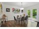 Modern dining area with a glass table, hardwood floors, and bright doors to the backyard at 495 Ramsdale Dr, Roswell, GA 30075