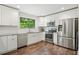 Modern kitchen featuring stainless steel appliances, granite countertops, and dark hardwood flooring at 495 Ramsdale Dr, Roswell, GA 30075