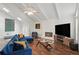 Bright living room showcasing vaulted ceilings, modern art, fireplace, and comfortable blue seating at 495 Ramsdale Dr, Roswell, GA 30075