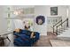 Open living room with stairs to loft, vibrant art, and modern staircase leading to the upper level at 495 Ramsdale Dr, Roswell, GA 30075