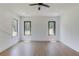 Bright and airy bedroom featuring wood floors and abundant natural light from multiple windows, complete with a ceiling fan at 51 Deer Canyon Dr, Auburn, GA 30011