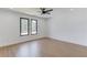 Well-lit bedroom with hardwood floors, a ceiling fan, and two large windows providing natural light at 51 Deer Canyon Dr, Auburn, GA 30011