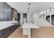 Spacious kitchen with a large island, black cabinetry, and stairs leading up at 51 Deer Canyon Dr, Auburn, GA 30011