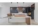Unfinished kitchen with a large island, modern pendant lights, and sleek black cabinets at 51 Deer Canyon Dr, Auburn, GA 30011