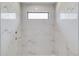 Shower with white marbled tile and a transom window at 51 Deer Canyon Dr, Auburn, GA 30011