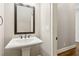 Pedestal sink and mirror in a half bathroom with hardwood floors and neutral walls at 565 Stone Field Nw Run, Marietta, GA 30060