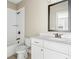 Bathroom with white vanity, framed mirror, and shower and tub combination with classic bronze plumbing fixtures at 565 Stone Field Nw Run, Marietta, GA 30060