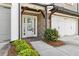 Inviting home entrance with a glass front door, a tiled stoop, and manicured shrubs at 565 Stone Field Nw Run, Marietta, GA 30060