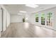 Large basement with gray wood-look floors, white walls, windows, and access to the outside at 1100 Kensington Ct, Johns Creek, GA 30022