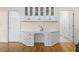 A home office area with white cabinets, drawers, a desk, and glass door storage on hardwood flooring at 1100 Kensington Ct, Johns Creek, GA 30022