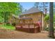 Brick home with a spacious wooden deck, a lush green lawn, and mature trees for privacy at 1100 Kensington Ct, Johns Creek, GA 30022